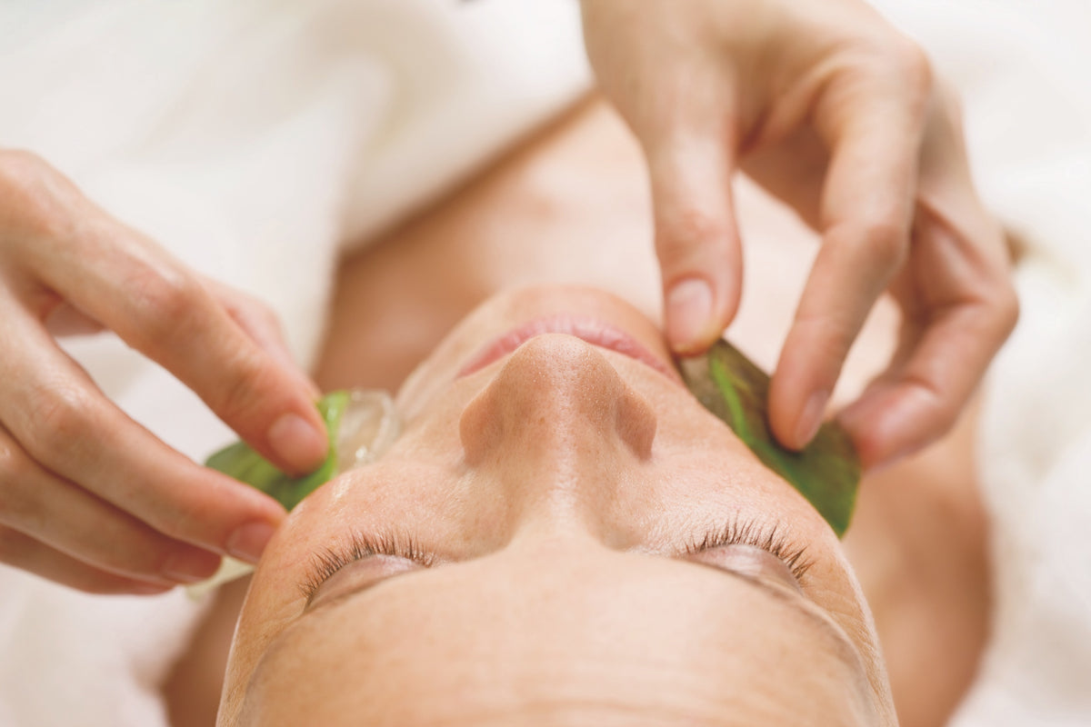 Nahaufnahme einer Frau, die mit Aloe Vera im Gesicht behandelt wird