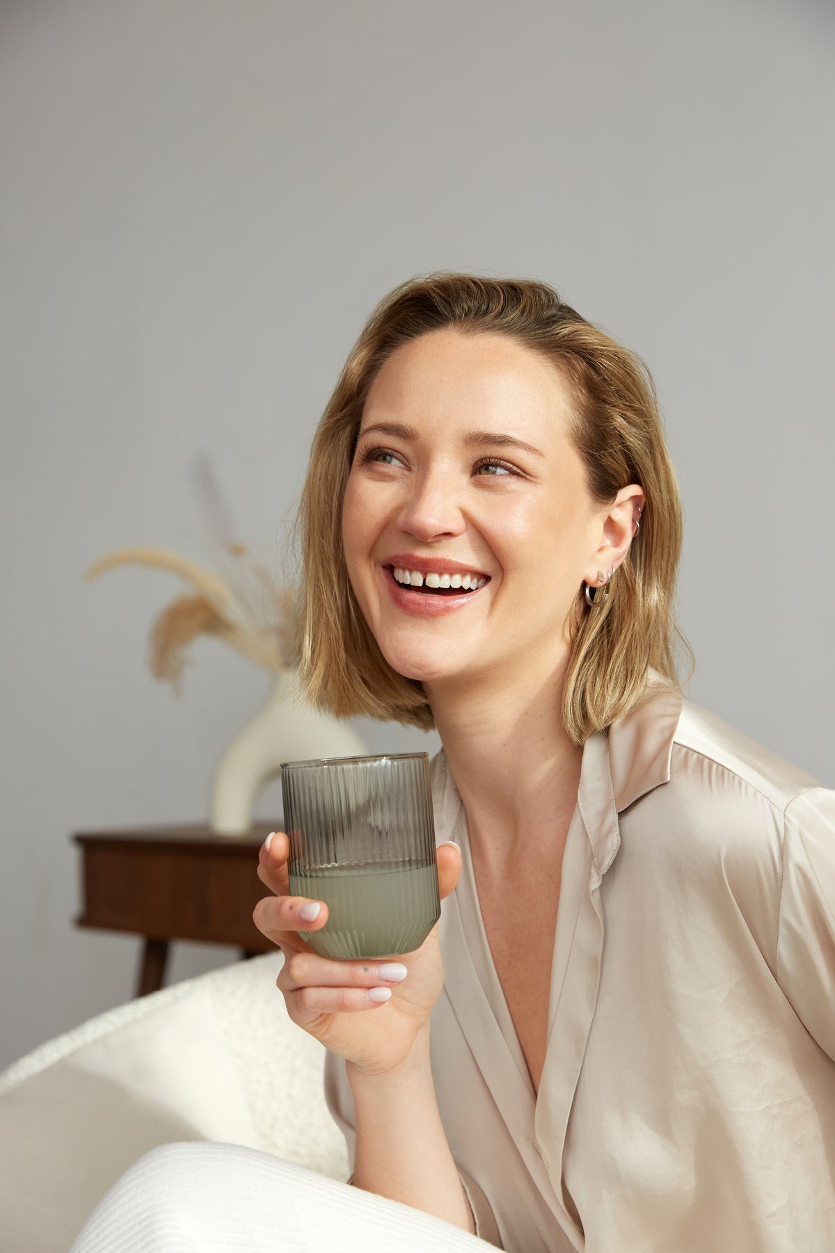 Frau hält Aloe Vera Saft Glas in der Hand und lächelt