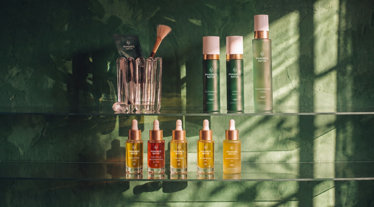 Eine Vitrine mit verschiedenene Pharmos Natur Produkten, beleuchtet von Sonnenlicht, grüner Hintergrund