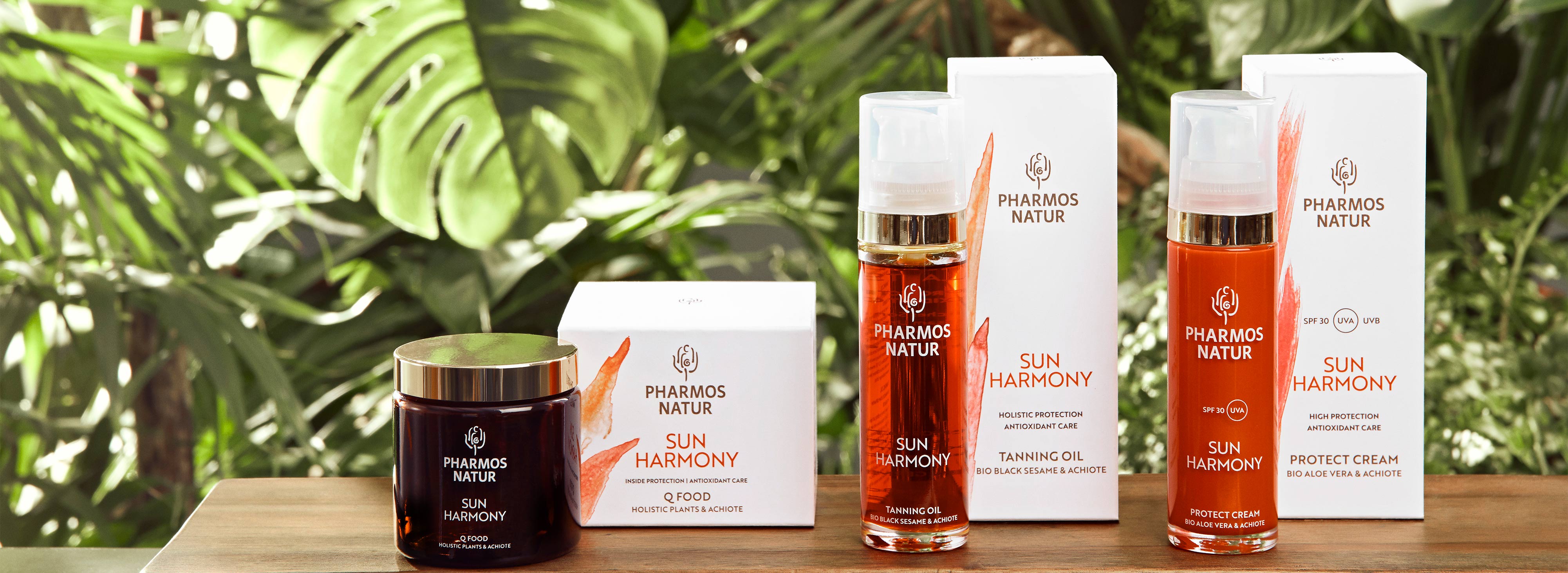 Drei rote Sun Harmony Produkte einschließlich Q Food vor einem Blätter Hintergrund