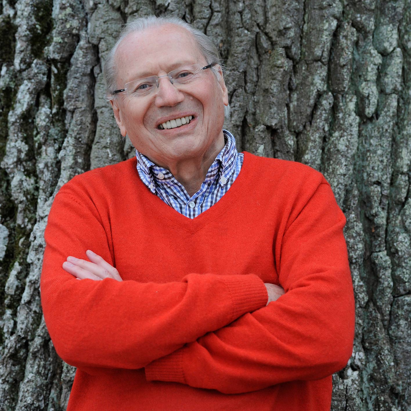 Paul Greineder Portrait lächelnd vor einem Baumstamm