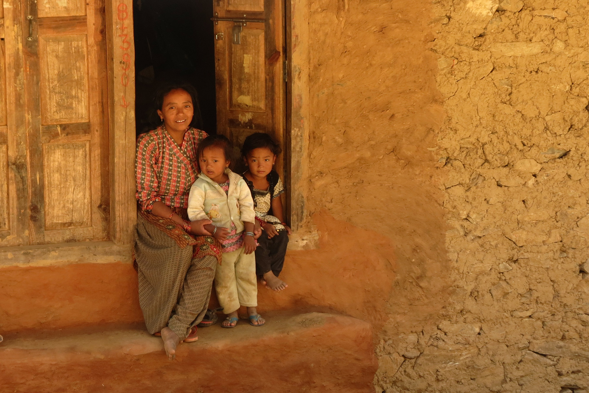 Nepal Einheimische Frau mit Kindern Mutter mit zwei Kindern in altem Stein Haus Einheimische