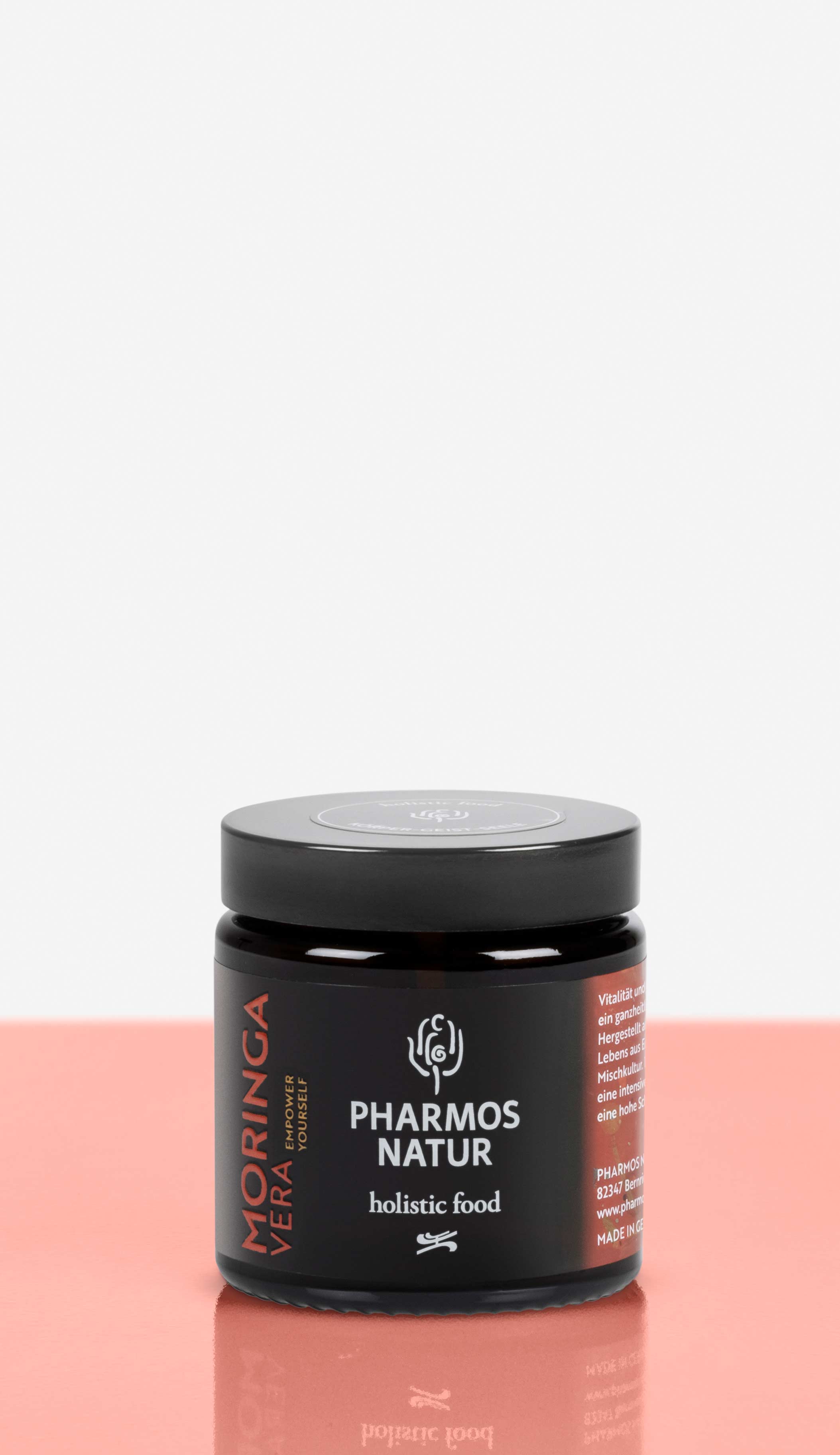 Moringa Vera dunkler Behälter Produktbild neben Pulver und Verpackung